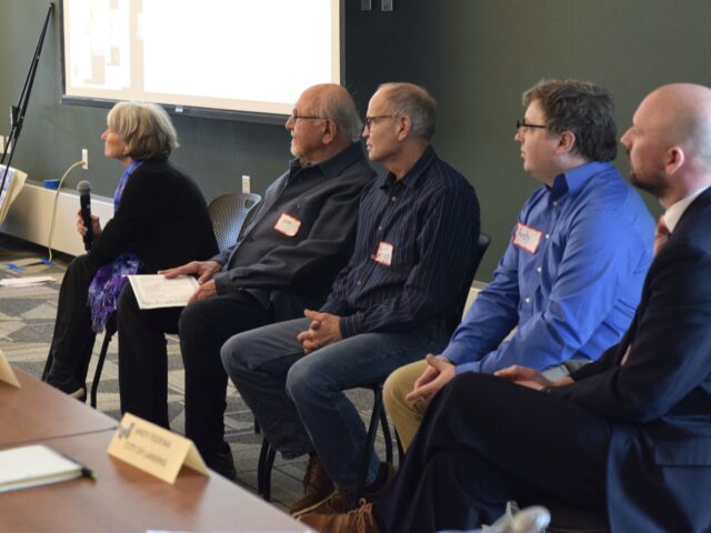 Seated attendees listen intently to a presenter